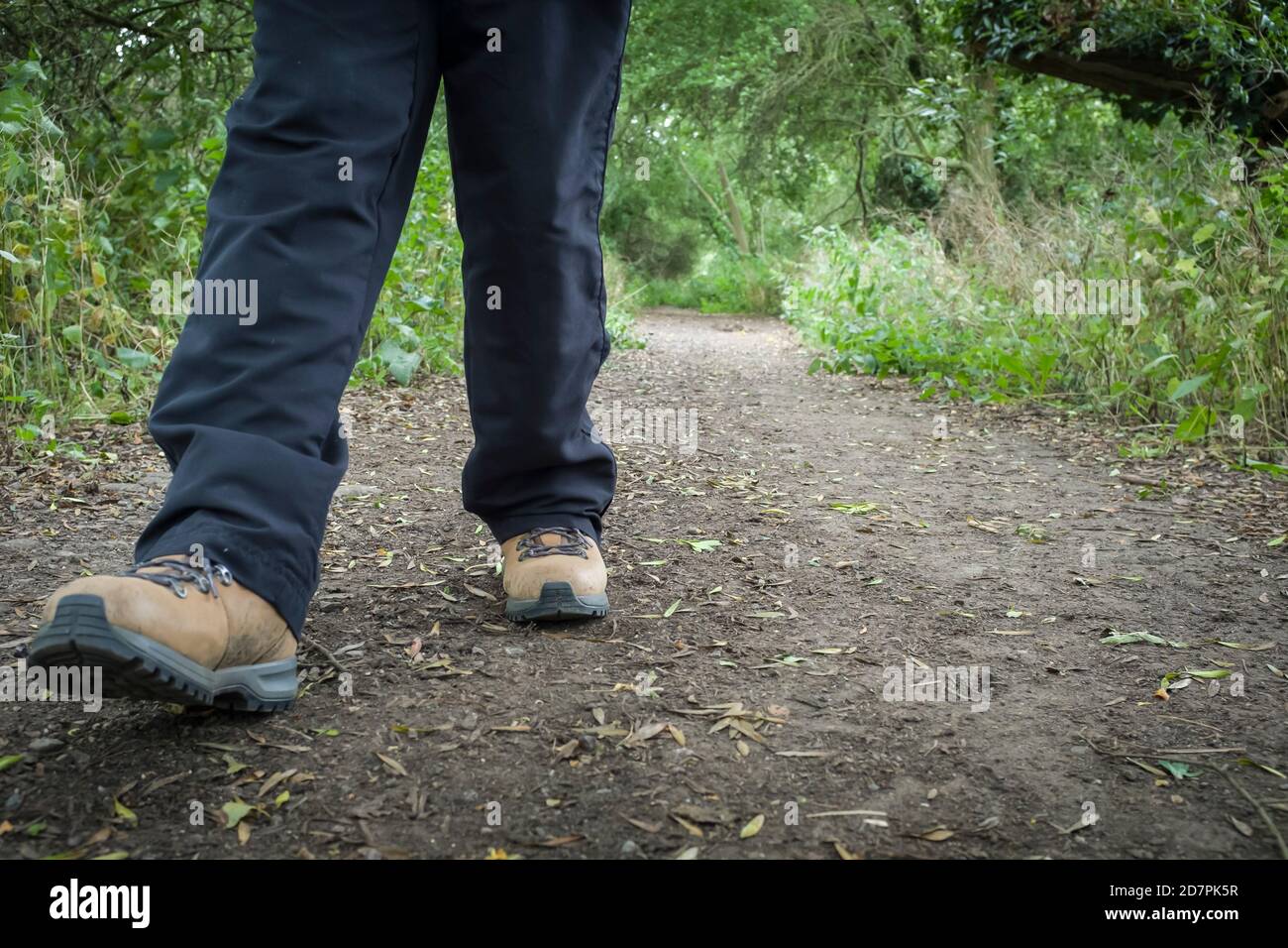 Frau trägt Wanderschuhe Wandern auf einem Wanderweg in Großbritannien Auf dem Land Stockfoto