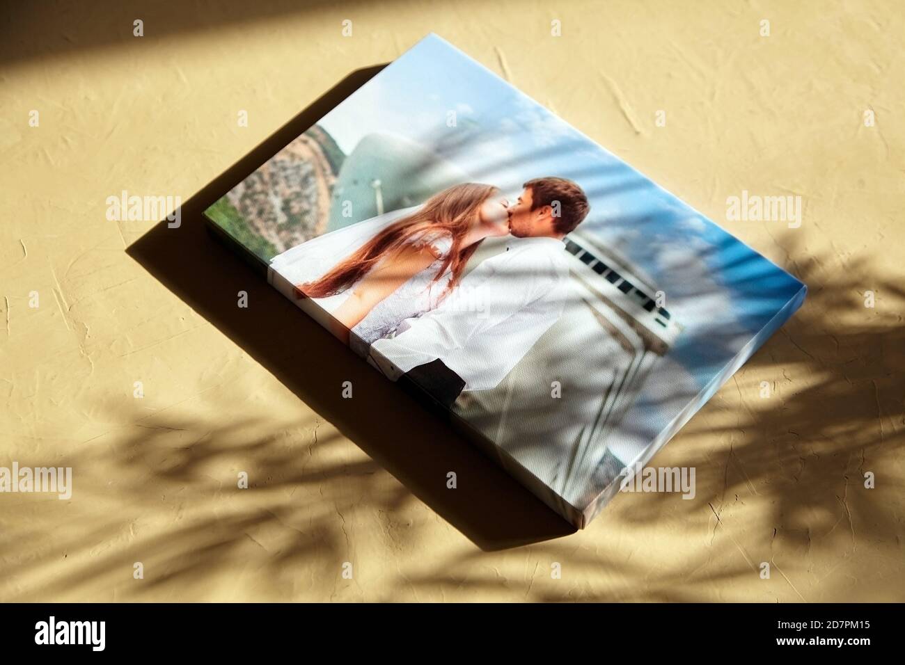 Leinwanddruck mit Gallery Wrap auf der Oberfläche mit Sonnenlicht und Schatten der Blätter. Hochzeitsfoto auf Leinwand gedruckt Stockfoto