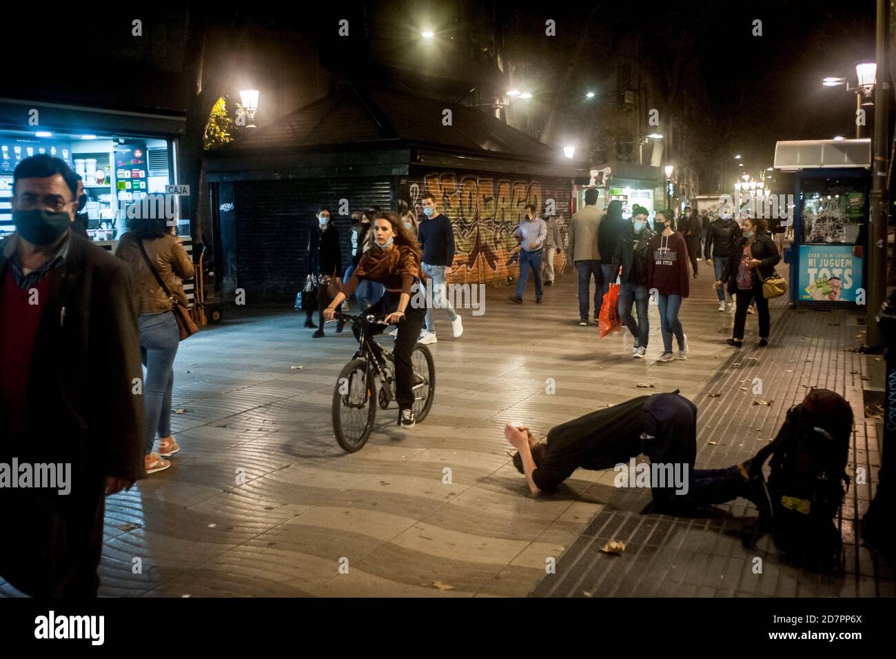 Barcelona, Spanien. Okt. 2020. Auf den Ramblas von Barcelona postriert ein Mann und bittet um Almosen, während Fußgänger mit Gesichtsmasken den Boulevard hinunter gehen. Spanien Gerät in einen weiteren Alarmzustand, nachdem acht Regionen die Regierung aufgefordert haben, die Notfallmaßnahme umzusetzen, um Coronavirus-Infektionen einzudämmen. Quelle: Jordi Boixareu/Alamy Live News Stockfoto