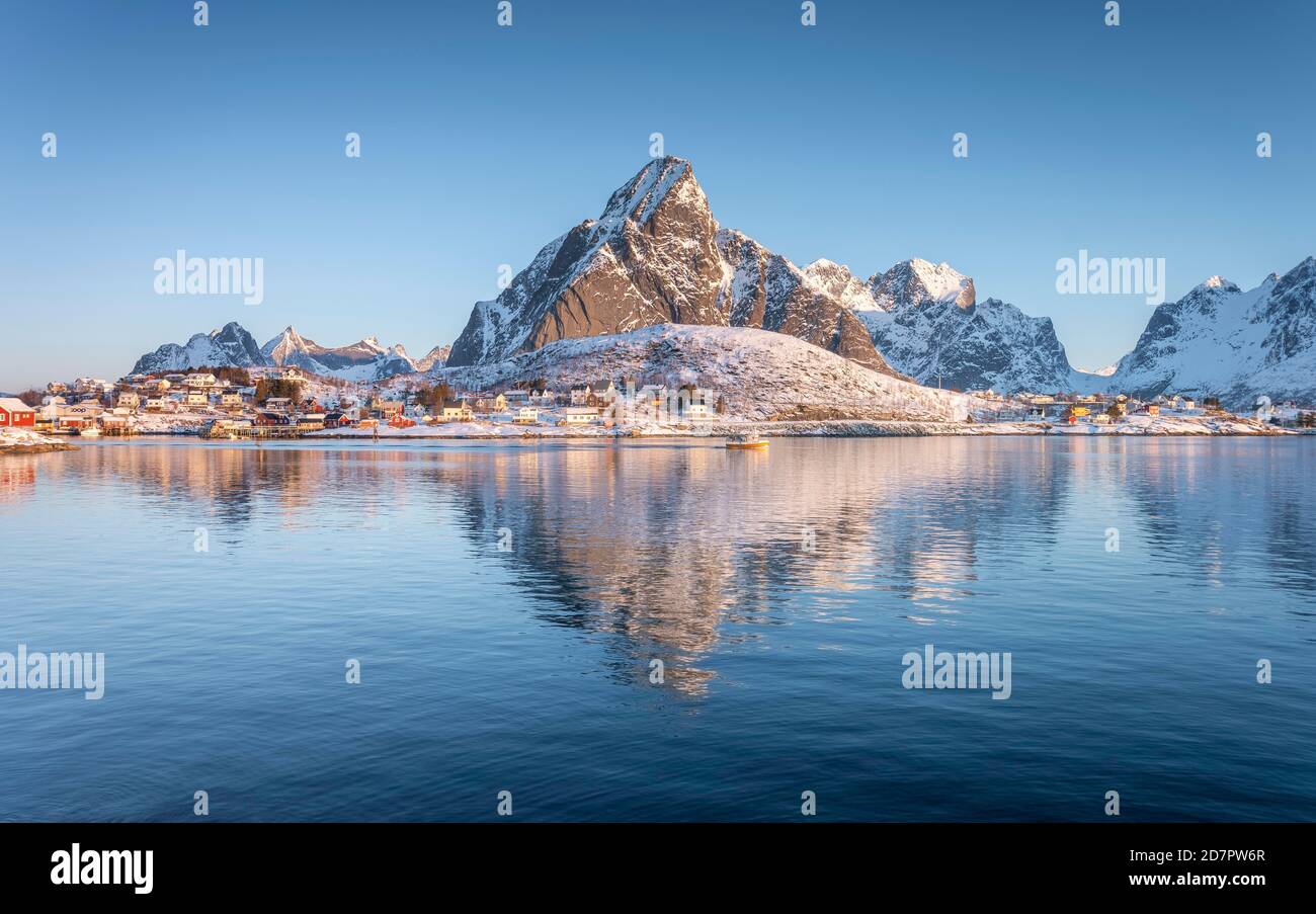 Fischerdorf spiegelt sich im Meer, verschneite Berge im Hintergrund, reine, Nordland, Lofoten, Norwegen Stockfoto