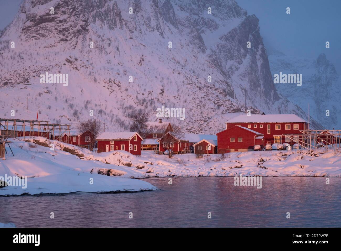 Winterstimmung am frühen Morgen im Fischerdorf, Stockfischregale, Schneefall in den Bergen, reine, Nordland, Lofoten, Norwegen Stockfoto
