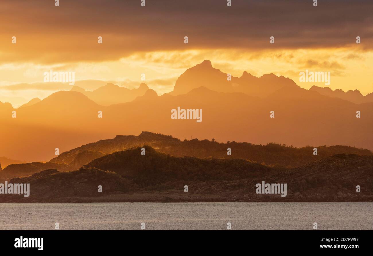 Stimmungsvoller Sonnenuntergang über einem hohen Gebirge, vor dem Meer, Bodo, Nordland, Norwegen Stockfoto