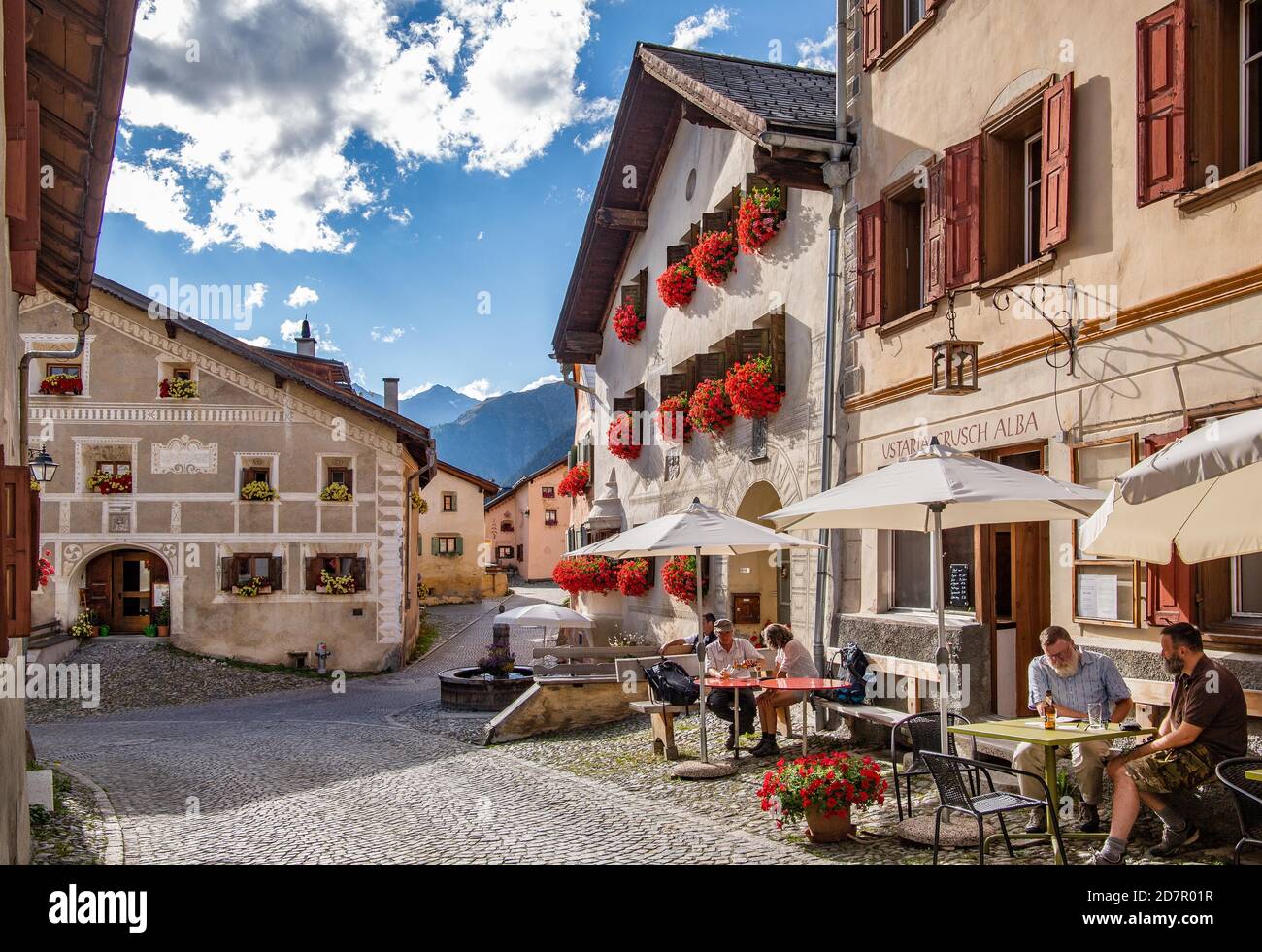 Dorfstraße mit Restaurantterrasse und typischen Häusern, Bergdorf Guarda, Inntal, Unterengadin, Engadin, Graubünden, Schweiz Stockfoto