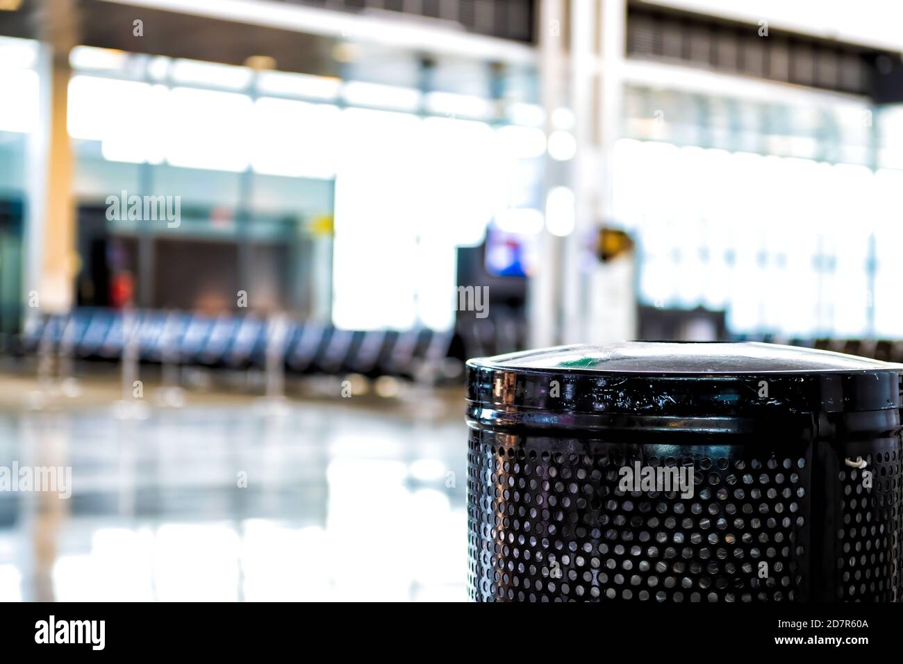Flughafen-Interieur mit schwarzem Mülleimer Mülleimer im Vordergrund Und verschwommener Bokeh-Hintergrund des Wartebereichs am Abflugsteig Niemand leer Stockfoto