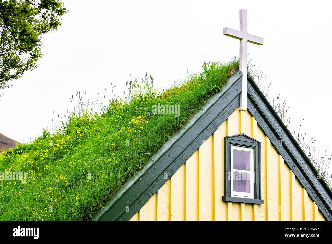 Hof, Island Kirche Nahaufnahme, die das letzte Gebäude in traditionellen Rasen-Stil, Hofskirkja, Gebäude Dach mit grünem Gras und bewölktem Himmel backgro bedeckt war Stockfoto