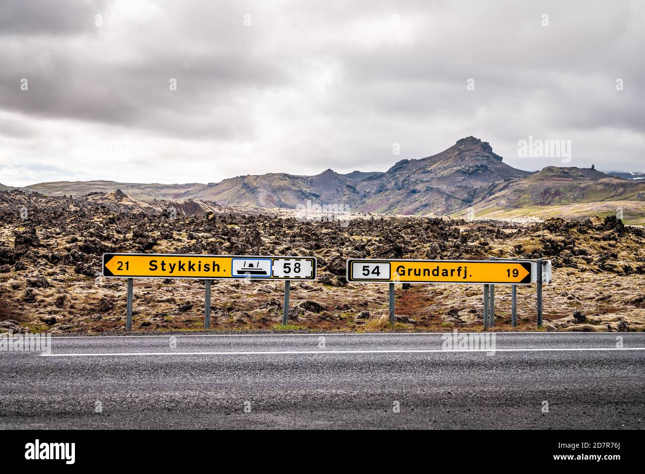 Schwarzes Lavafeld auf der Halbinsel Snaefellsnes in Island mit Richtung Schilder für Stykkish Stykkisholmur und Grundarfjordur mit niemand auf leer Straße Stockfoto