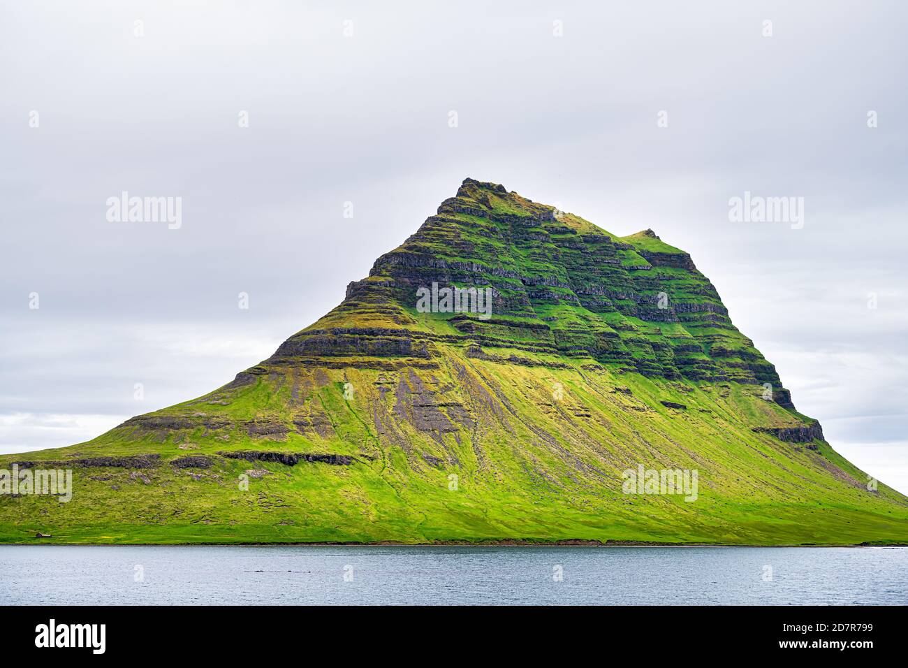 Grundarfjordur, Island Kirkjufell Berg an bewölktem bewölktem Tag kleines Fischerdorf auf Snaefellsnes Halbinsel mit üppigem grünen Gras im Sommer Stockfoto