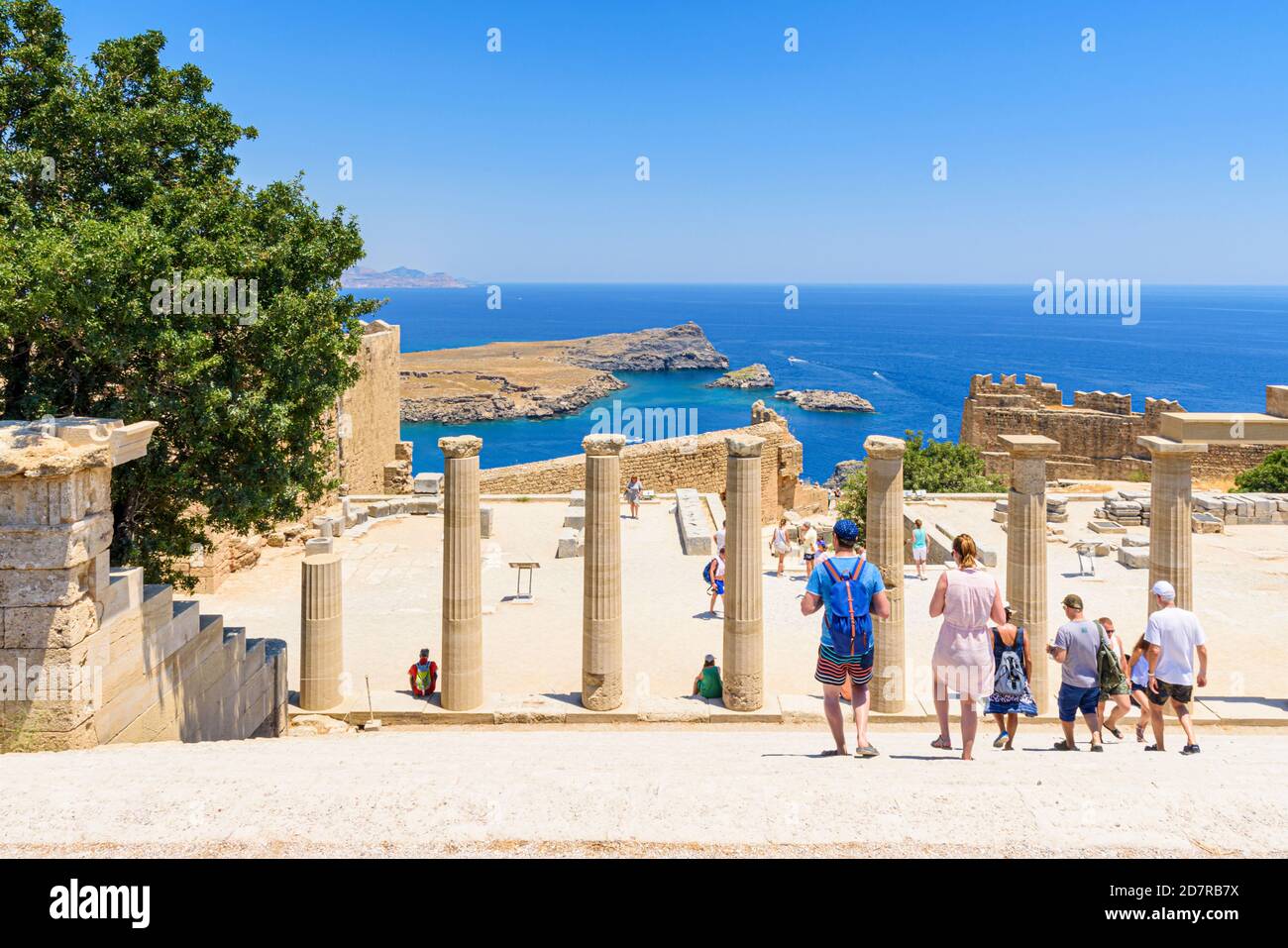 Touristen gehen die Treppe hinunter, die zu den Stoa Ruinen auf der Akropolis von Lindos, Rhodos, Griechenland führt Stockfoto