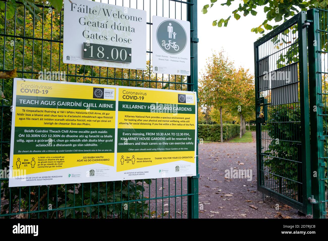 Gelbes Infotafel-Schild für die Regeln der sozialen Distanzierung und des Cocooning im Park am Eingang des Killarney House and Gardens Estate in Killarney, Irland Stockfoto