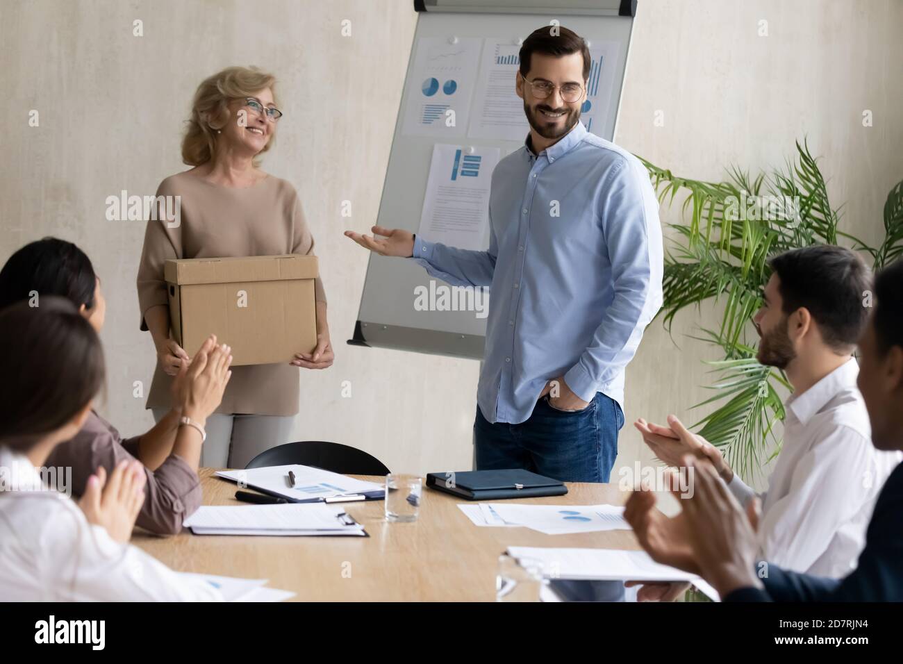 Lächelnde Geschäftsfrau stellt neue Mitarbeiterin bei Teambesprechung vor Stockfoto