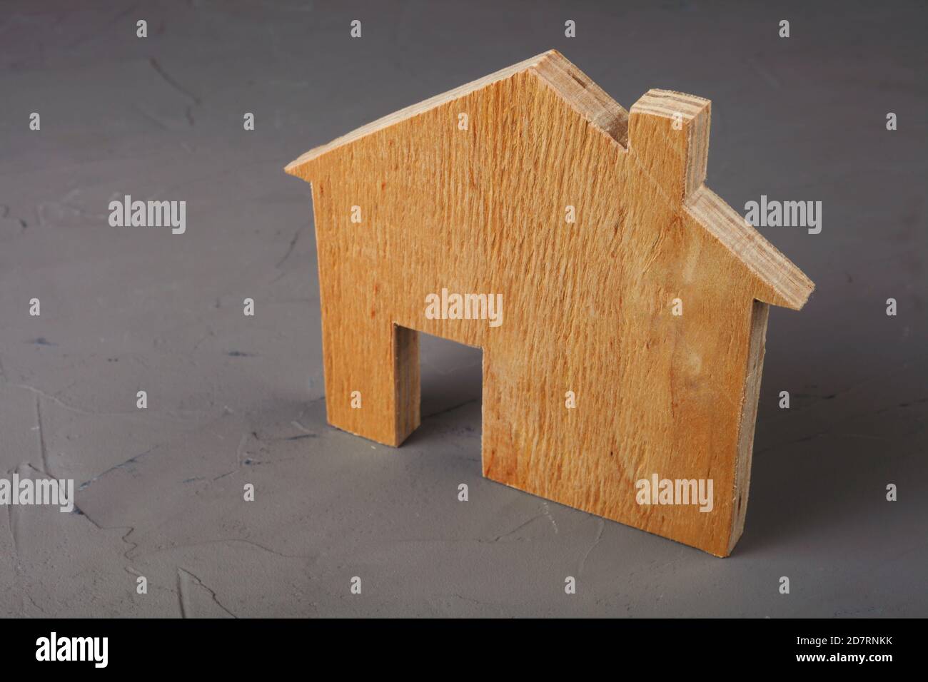 Holzmodell eines Hauses auf einem betonierten Hintergrund, Nahaufnahme. Stockfoto