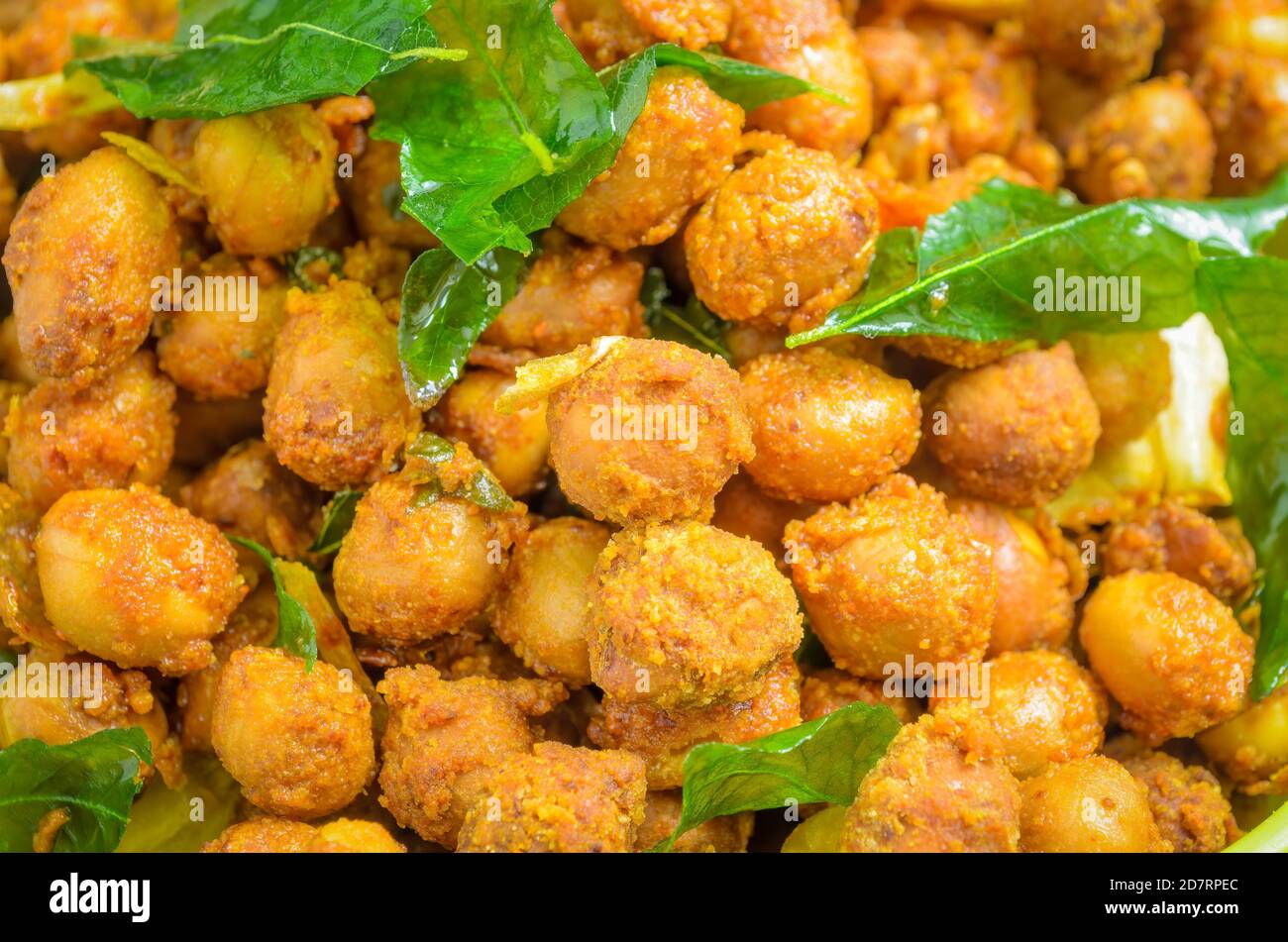 Nahaufnahme der Masala Erdnüsse garniert mit gebratenen Curryblättern und Knoblauch - Hintergrund Stockfoto