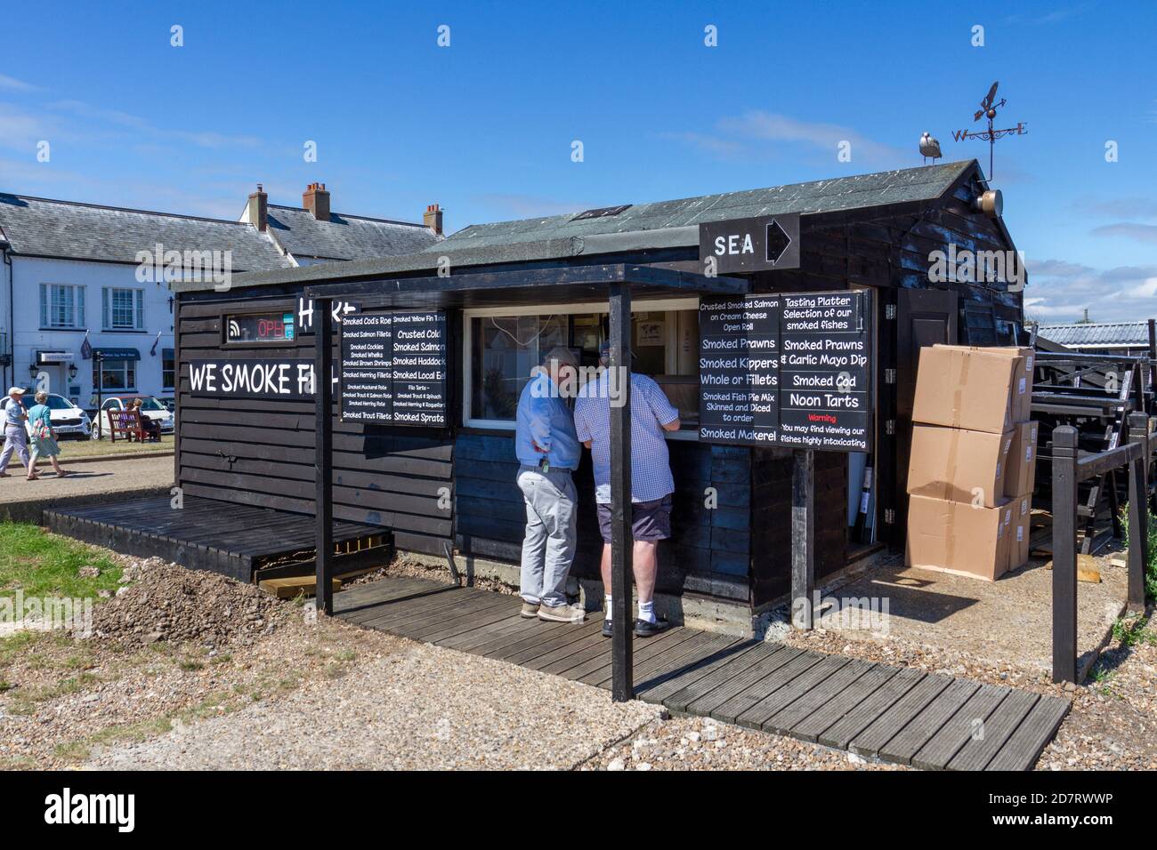 Kunden, die im Aldeburgh Smokehouse bedient werden, dem Frischfischgeschäft am Strand in Aldeburgh, Woodbridge, Suffolk, Großbritannien. Stockfoto