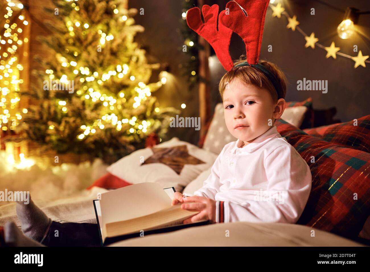 Junge las Bücher im Zimmer zu Weihnachten Stockfoto