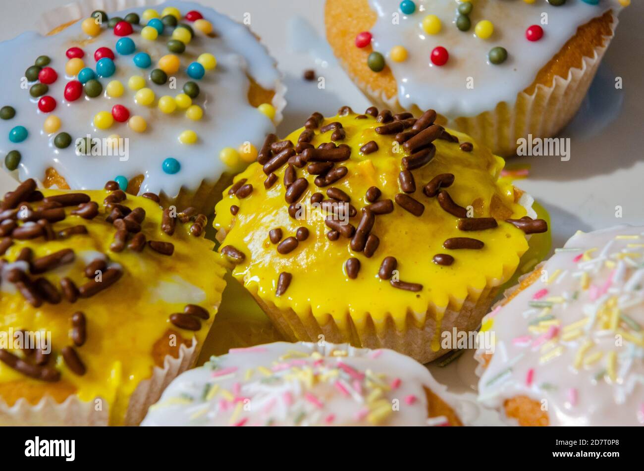 Nahaufnahme Blick auf hausgemachte Cupcakes mit Zucker Zuckerguss und Hunderte und Tausende dekoriert. Stockfoto