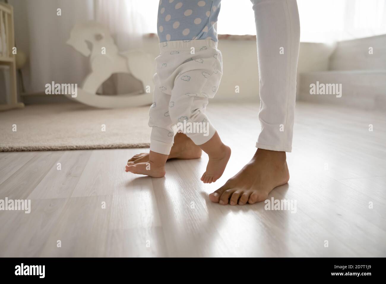 Nahaufnahme von Kleinkind machen erste Schritte halten Mutter Hände Stockfoto