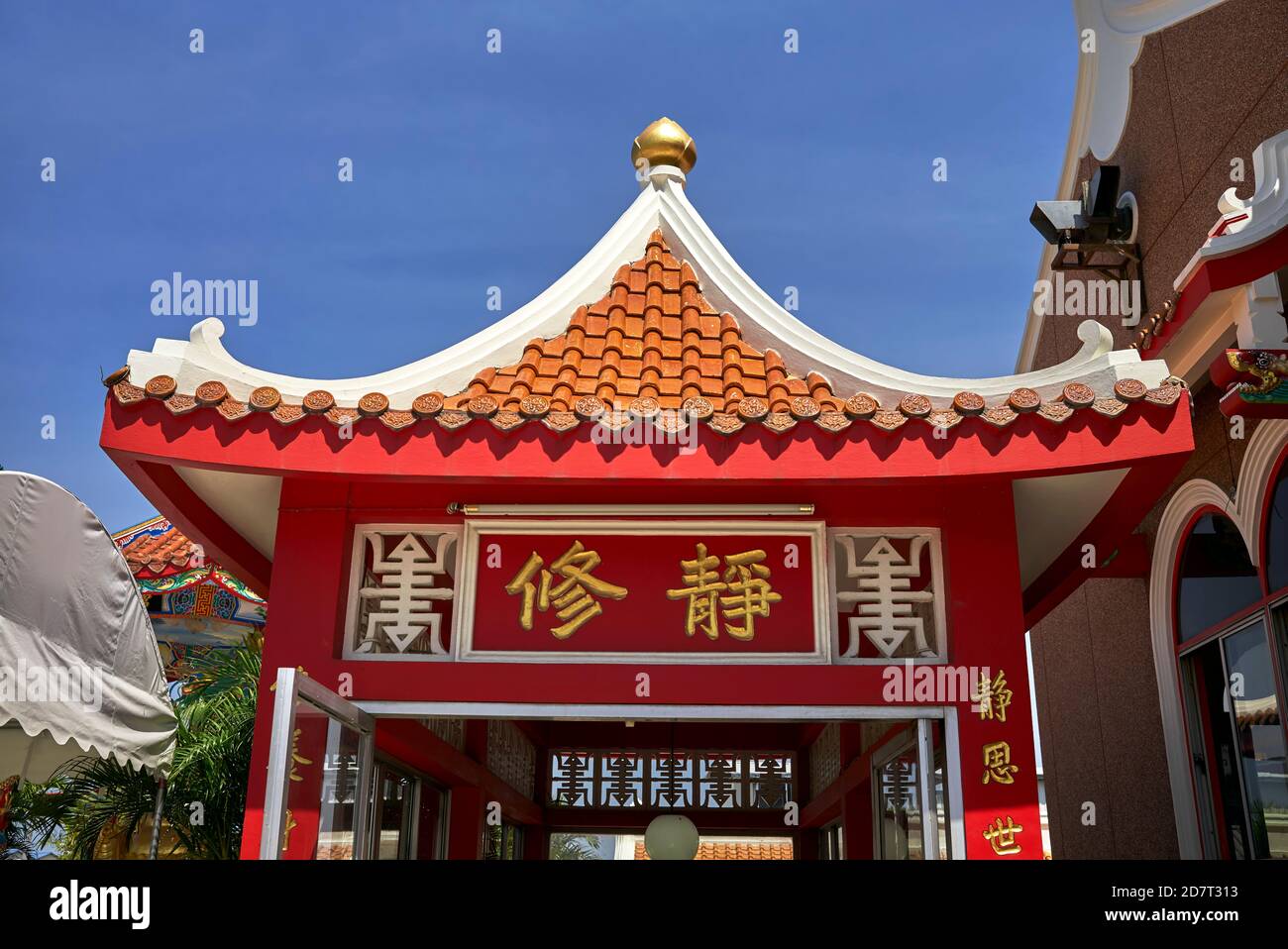 Kunstvolle chinesische Dachdetails an einem tiefblauen Sommerhimmel eines chinesischen Tempels. Thailand S. E. Asien. Stockfoto