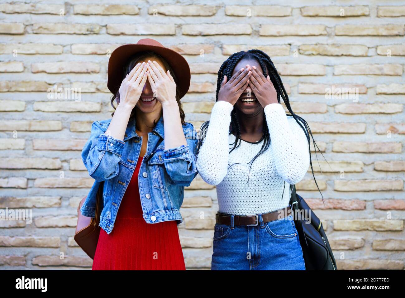 Zwei Freundinnen, die ihre Augen im Freien bedecken. Multiethnische Frauen. Stockfoto