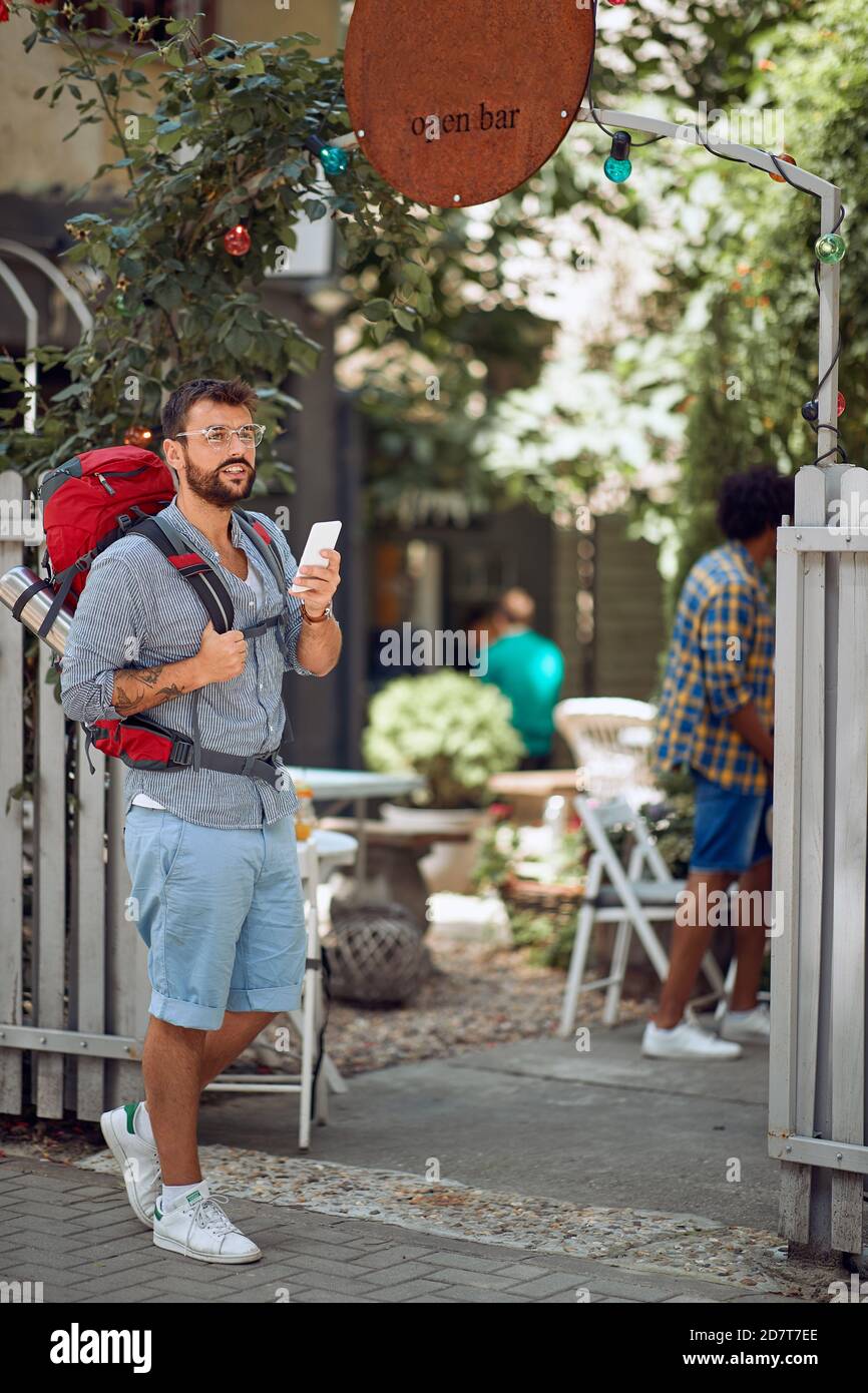 Junger männlicher Tourist vor der Herberge bei schönem Wetter. Reise-, Tourismus- und Personenkonzept Stockfoto