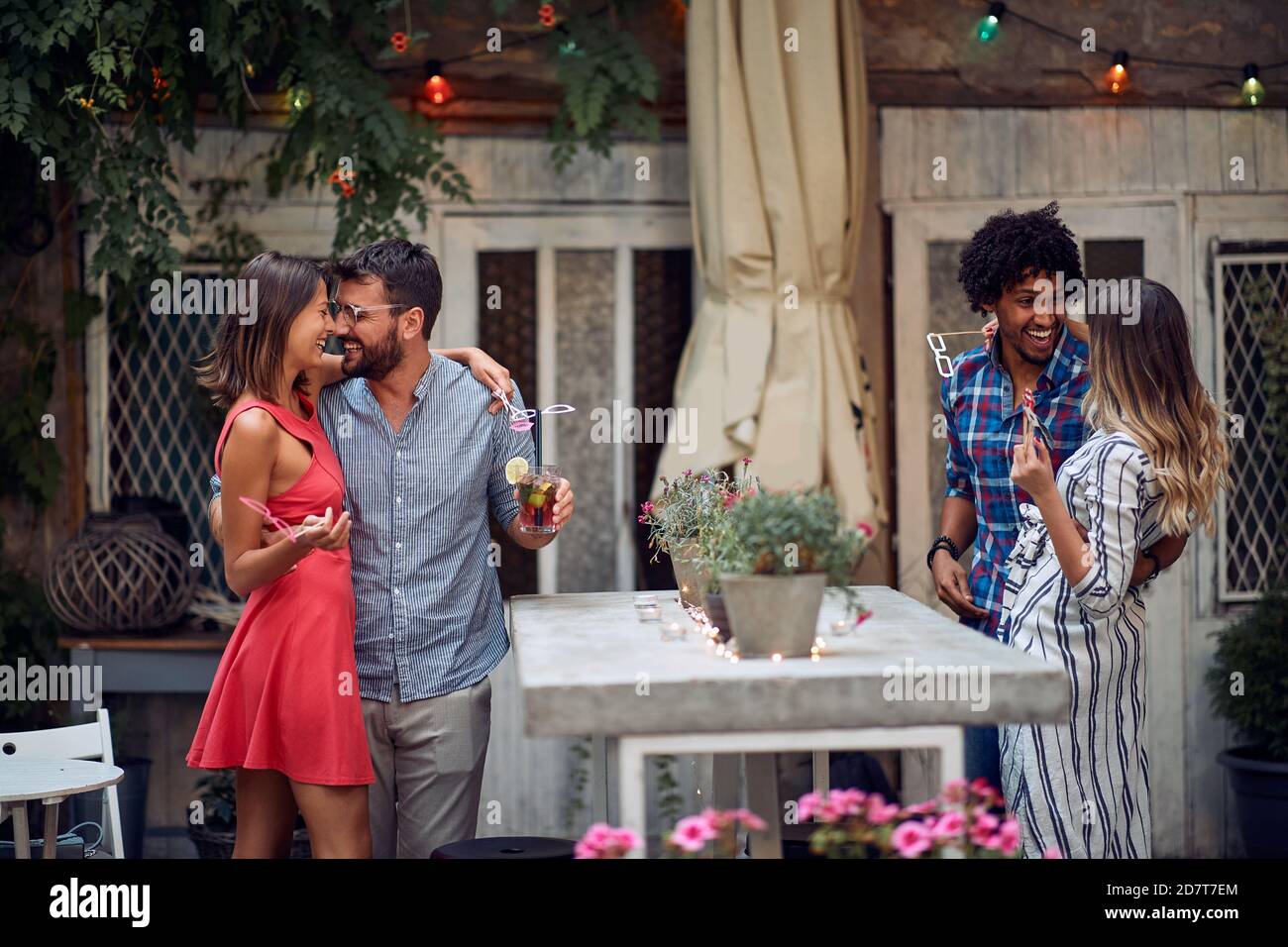 Schöne Paare auf der Open-Air-Geburtstagsparty in einer schönen Sommerdämmerung. Qualität Freundschaft Zeit zusammen Stockfoto