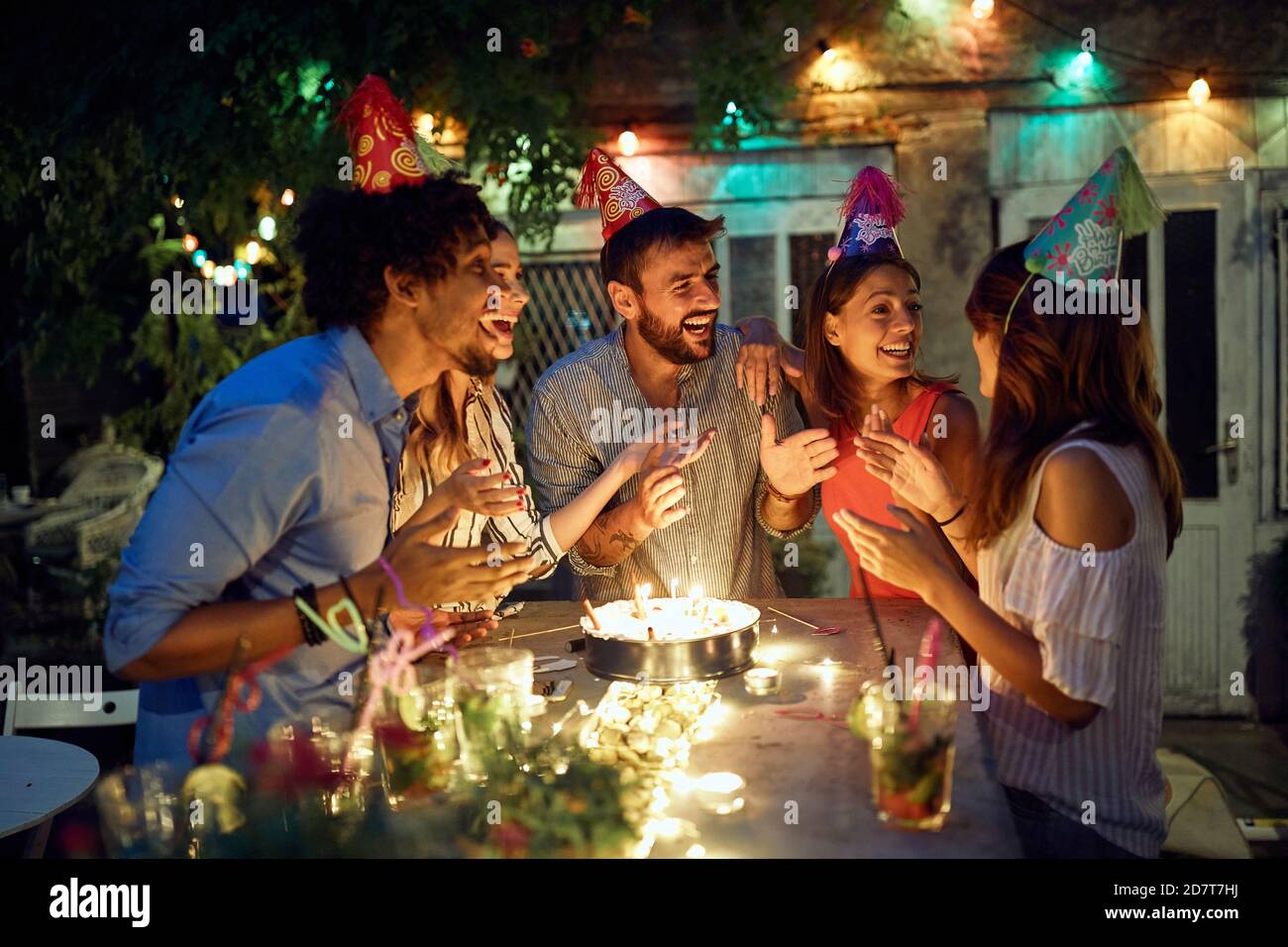 Eine Gruppe von fröhlichen Freunden genießen auf der Open-Air-Geburtstagsparty an einem schönen Sommerabend. Qualität Freundschaft Zeit zusammen Stockfoto