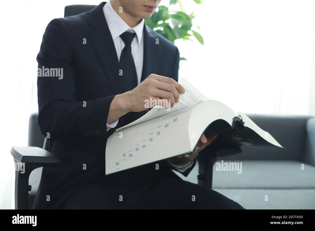 Rechtsanwalt liest Buch im Büro Stockfoto