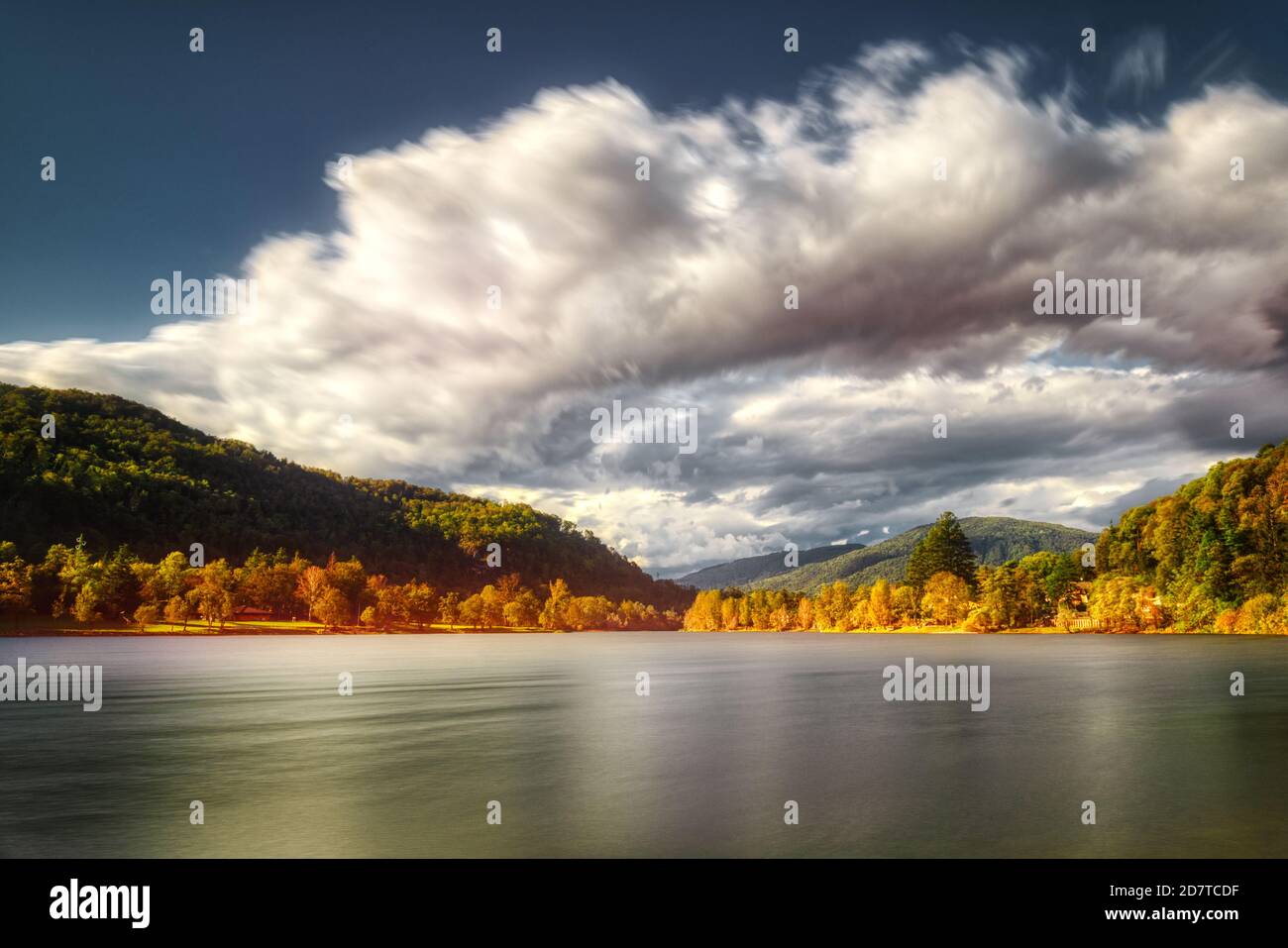 Herbstfarben am See Ghirla in Valganna mit Wolken vom Wind bewegt, lange Zeit Exposition Stockfoto