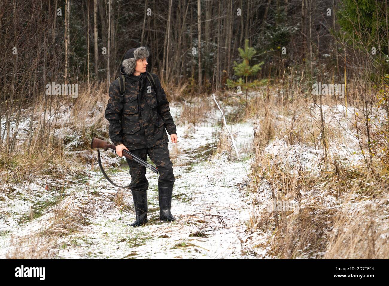 Hunter mit einer Waffe und einem Rucksack im Winter Wald Stockfoto