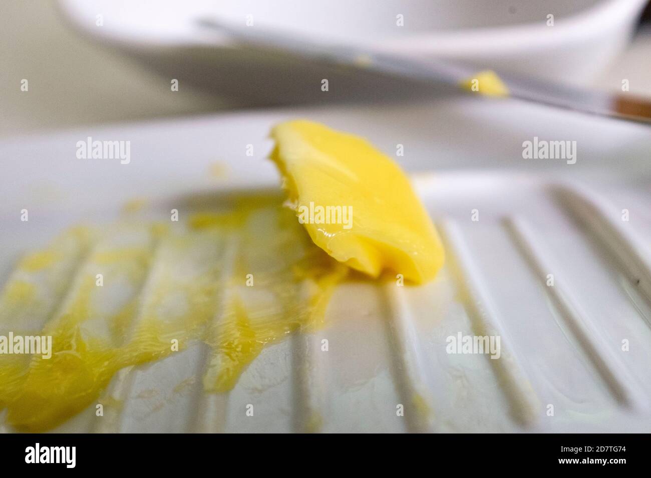 Letztes Stück Butter in Butterdose mit Messer Stockfoto