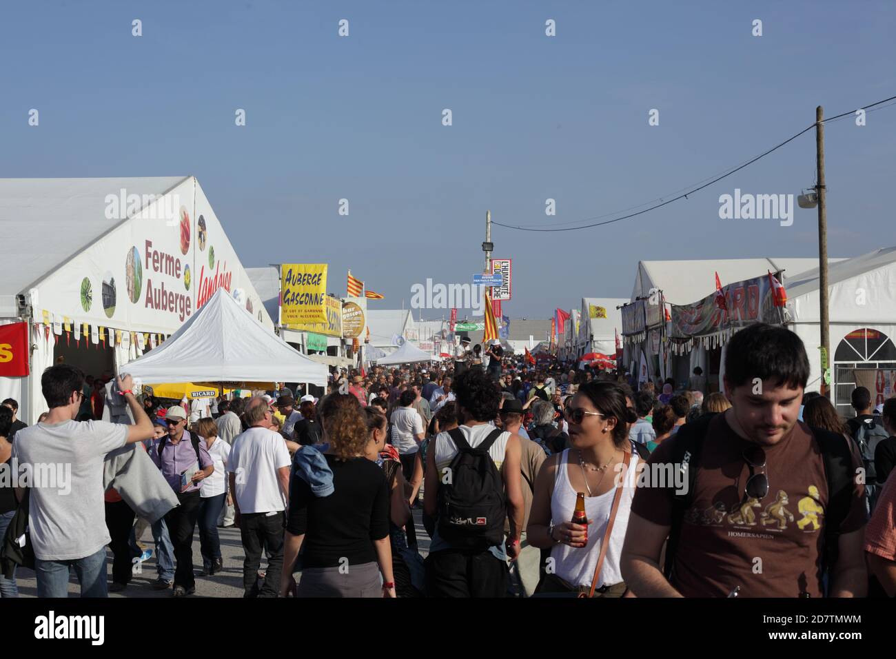 Fête de l'humanité 2014 : viele Menschen gehen in einer Gasse des Festivals der Menschheit und eine Frau hält ein Bier in der Hand beim Gehen Stockfoto