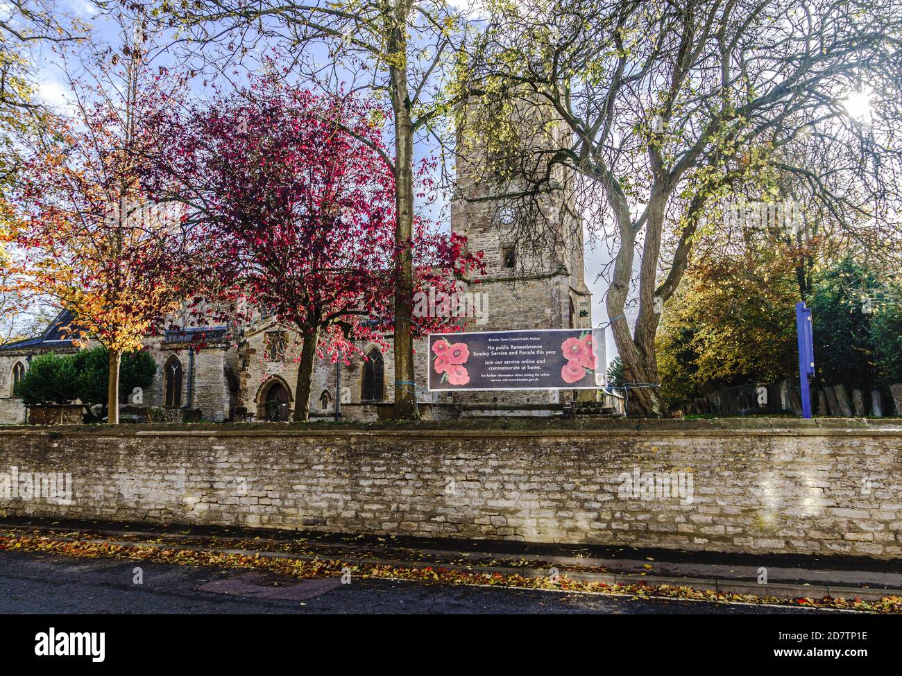 Banner vor der Kirche von St. Edburg (C/E), Bicester, North Oxfordshire, erinnert die Menschen daran, dass die Gedenkfeiertage online stattfinden werden. Stockfoto