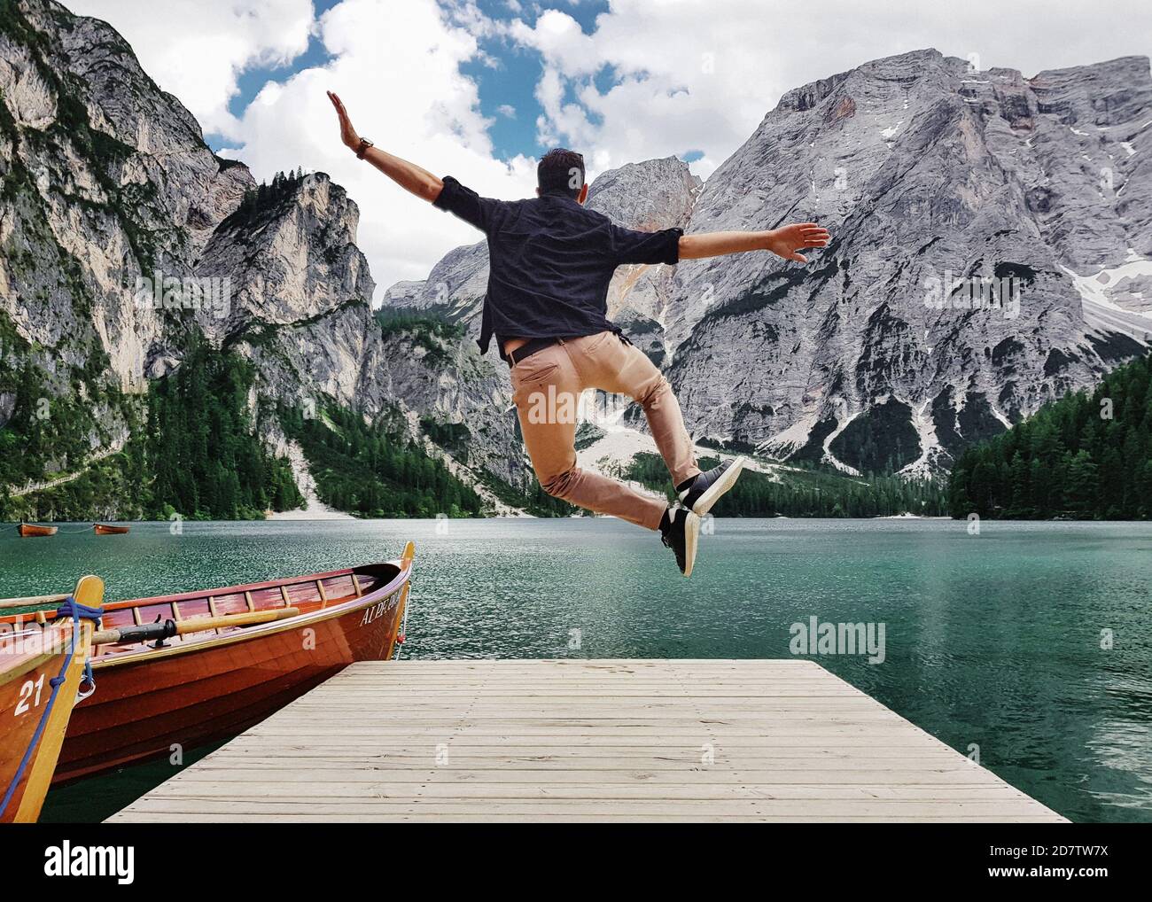 Rückansicht eines Mannes, der auf einem hölzernen Pier springt Der Naturpark Fanes-Sennes-Prags in Italien Stockfoto