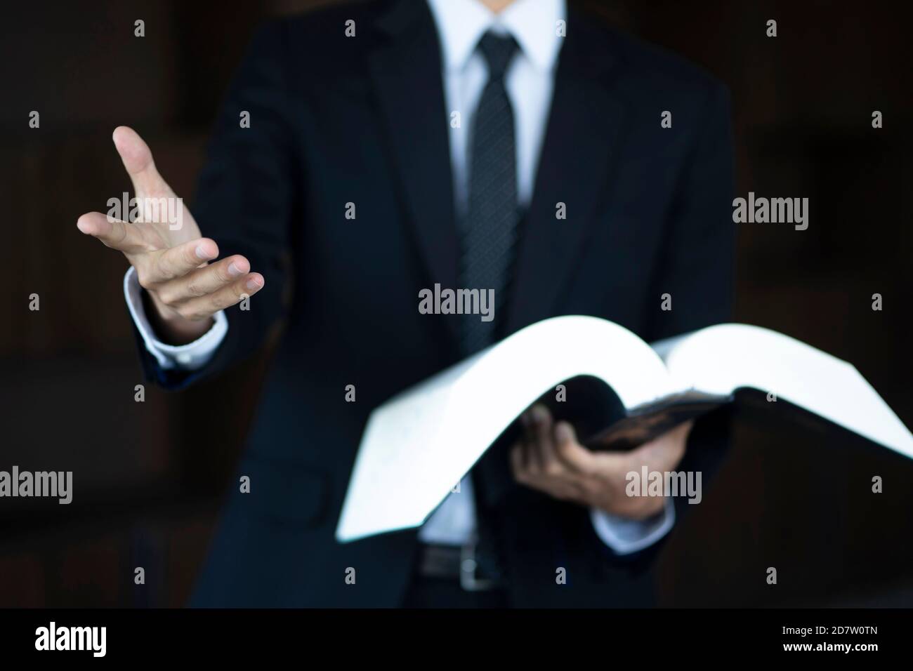 Zugeschnittenes Bild eines Rechtsanwalts, der ein Gesetzbuch hält Stockfoto