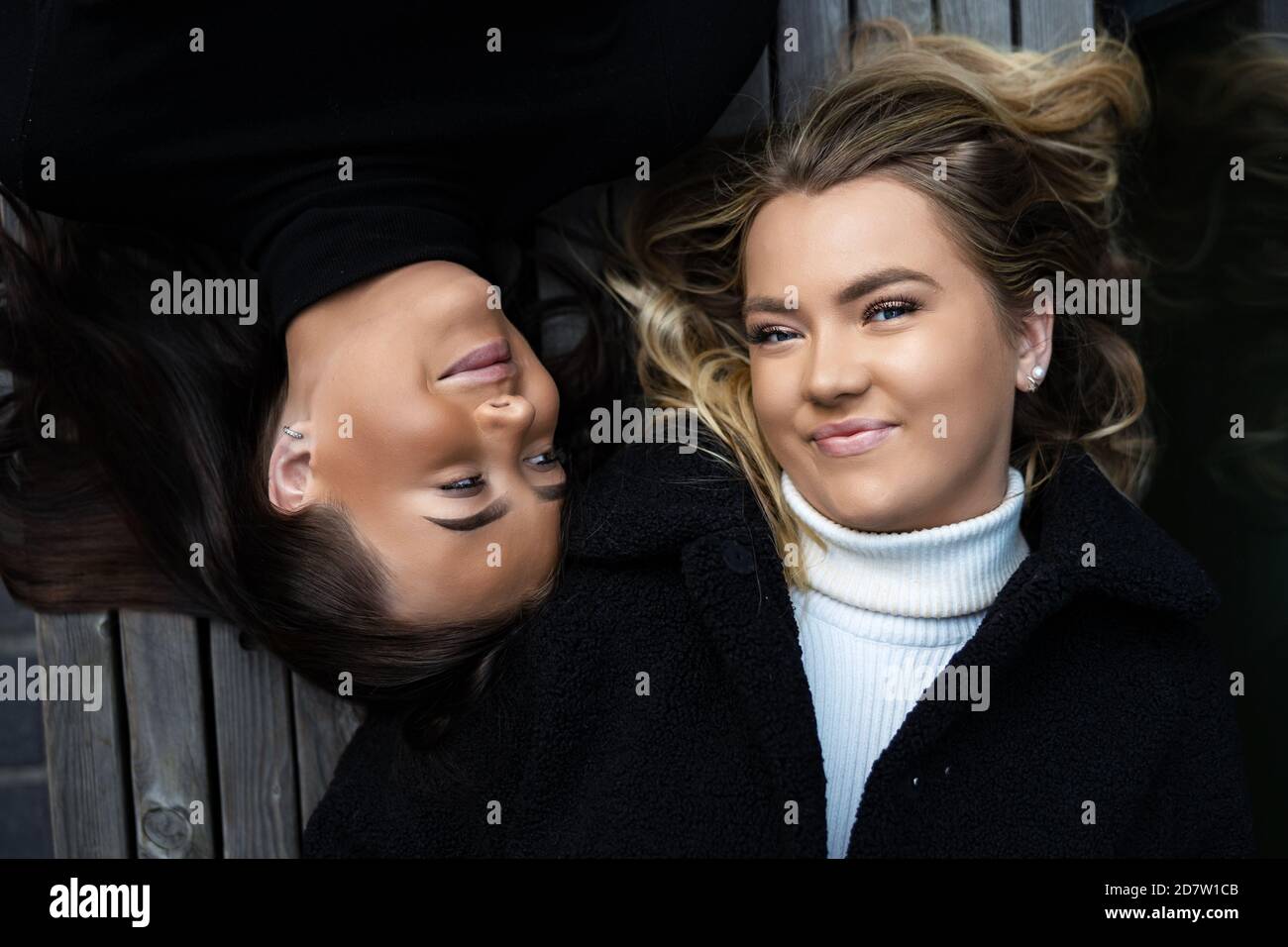 Porträt Von Zwei Lächelnden Besten Freunden Auf Der Bank Liegen Stockfoto