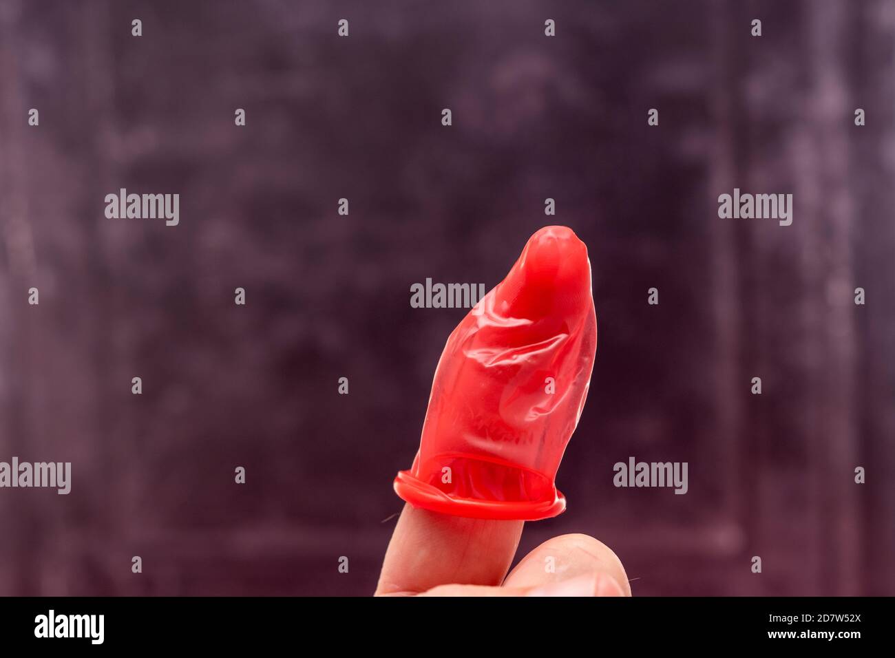 Latex-Kondom an einem Finger Stockfoto