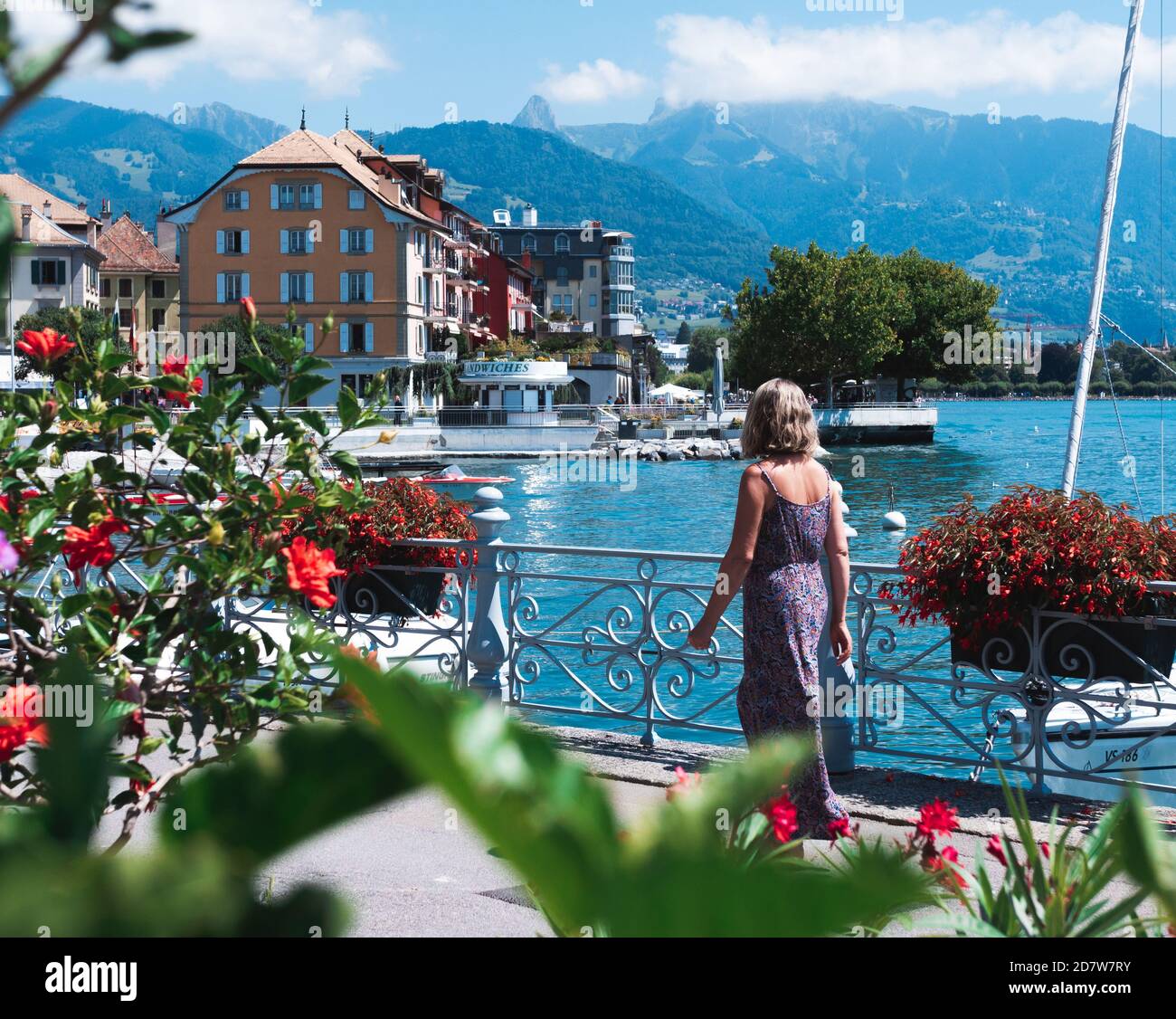 Frau mit violettem Kleid, die den Blick auf Vevey und seinen leman See in der Schweiz bewundert. Femme admirant la vue de Vevey et de son lac léman, Suisse. Stockfoto