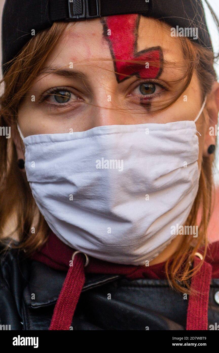 An der Demonstration nimmt eine Frau Teil, die eine Gesichtsmaske mit einem Blitzsymbol für den Frauenschlag auf dem Auge trägt.das Verfassungsgericht hat den Antrag einer Gruppe von Abgeordneten bezüglich der sogenannten eugenischen Abtreibung geprüft. Nach Ansicht des Gerichts ist eine solche Abtreibung, die bei Verdacht auf schwere fetale Defekte durchgeführt wird, mit der Verfassung unvereinbar. Frauen protestieren gegen die Entscheidung. Stockfoto
