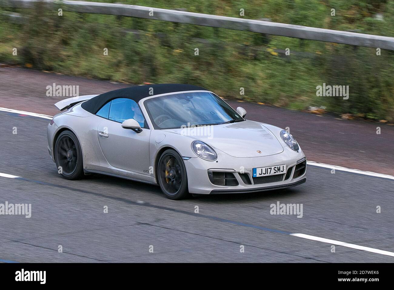 Porsche 911 Carrera GTS Gray Car Cabriolet Benzin fahrendes Fahrzeug auf der Autobahn M61 in der Nähe von Manchester, Großbritannien Stockfoto