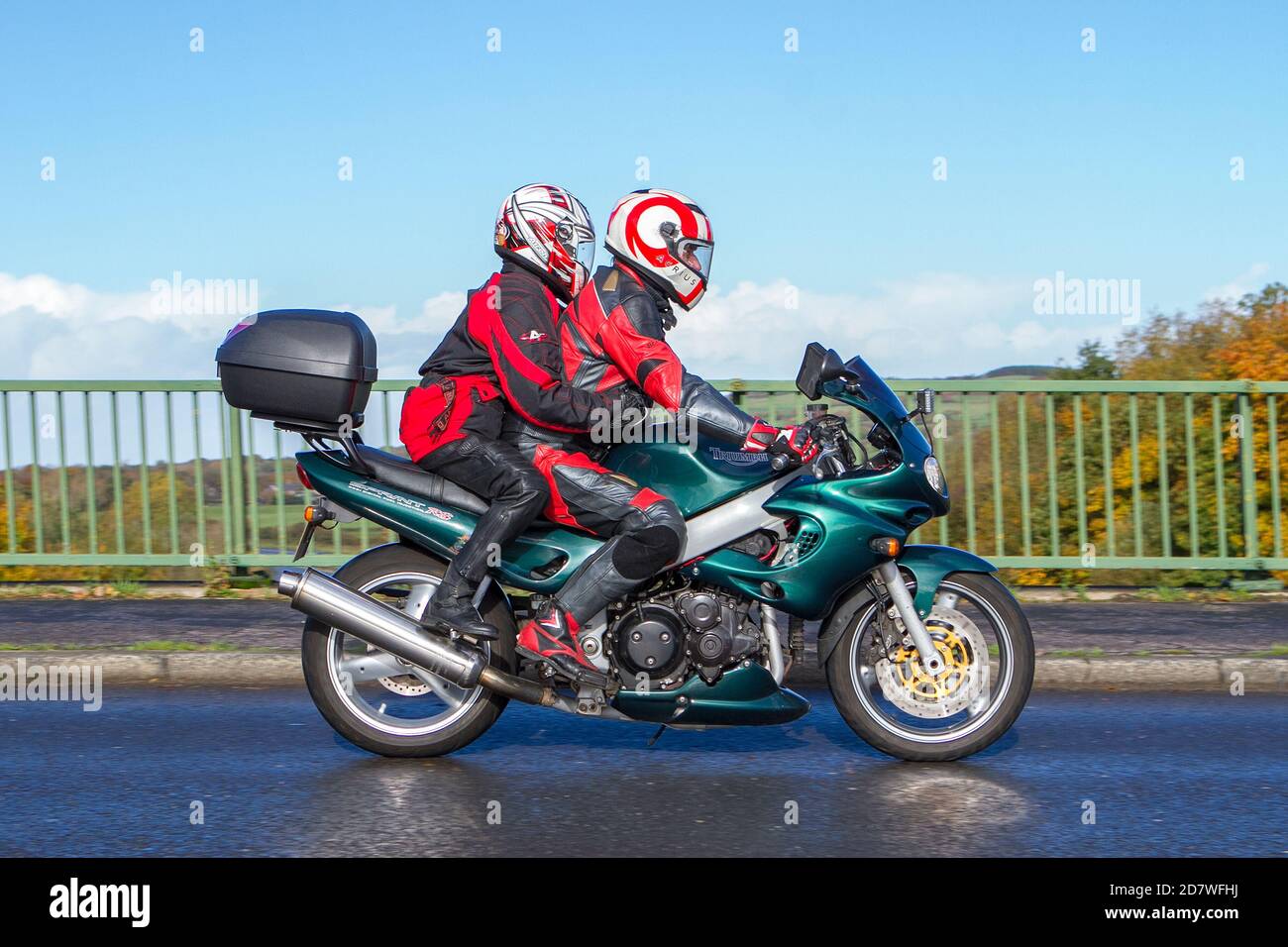 Ein Motorradfahrer & Sozius auf einem Triumph Sprint RS über die M6 Brücke in Rivington bei Chorley in Lancashire, UK Stockfoto