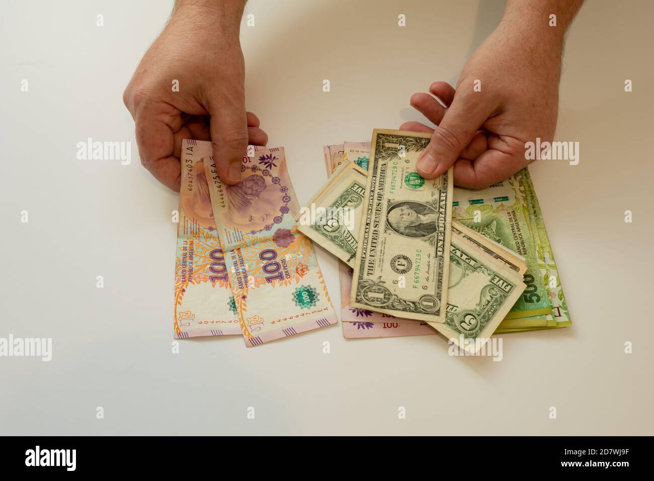 Austausch von Dollar gegen argentinische Pesos angesichts der Abwertung. Stockfoto