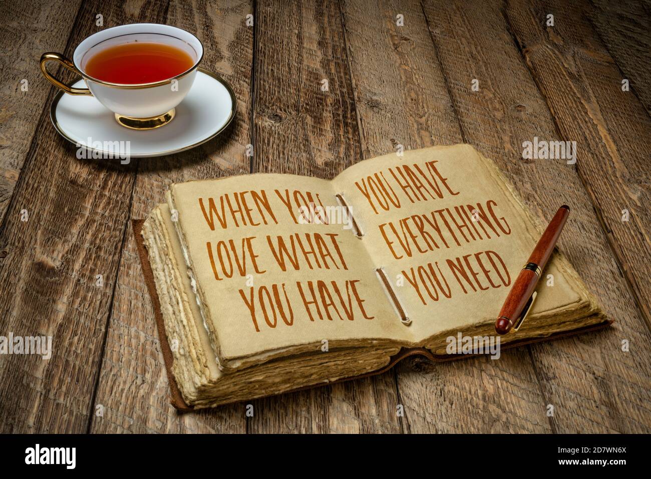Wenn Sie lieben, was Sie haben, haben Sie alles, was Sie brauchen - inspirierende Schreiben in einem Retro-Journal mit einer Tasse Tee, Weisheit und persönliche Entwicklung Stockfoto