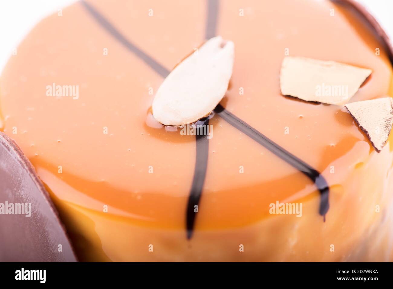Nahaufnahme von leckeren Schokoladenkuchen mit Mandel- und Orangendressing auf dem weißen Hintergrund. Stockfoto