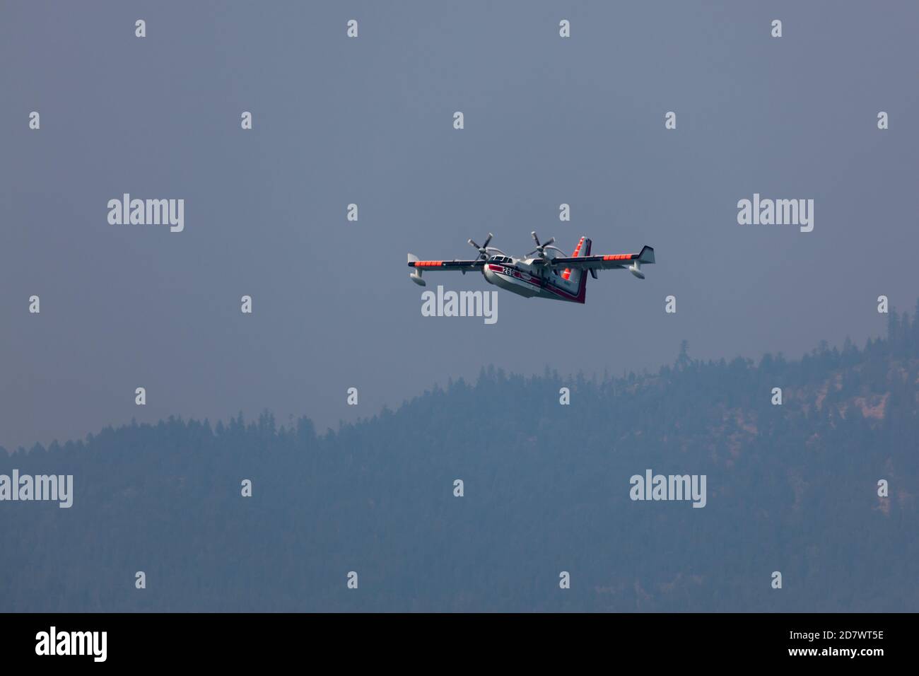 Lost Creek Lake in der Nähe von Prospect, Oregon / USA - 7. September 2014: Ein kleines Löschflugzeug bereitet sich darauf vor, Wasser zu schöpfen, da es tief über einem Berg hereinkommt Stockfoto