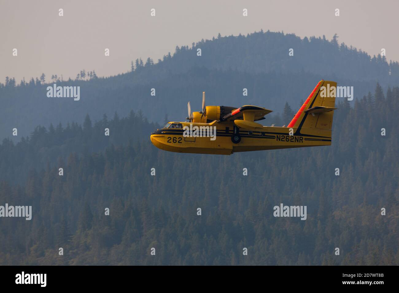 Lost Creek Lake in der Nähe von Prospect, Oregon / USA - 7. September 2014: Ein kleines Löschflugzeug bereitet sich darauf vor, Wasser zu schöpfen, da es tief über einem Berg hereinkommt Stockfoto