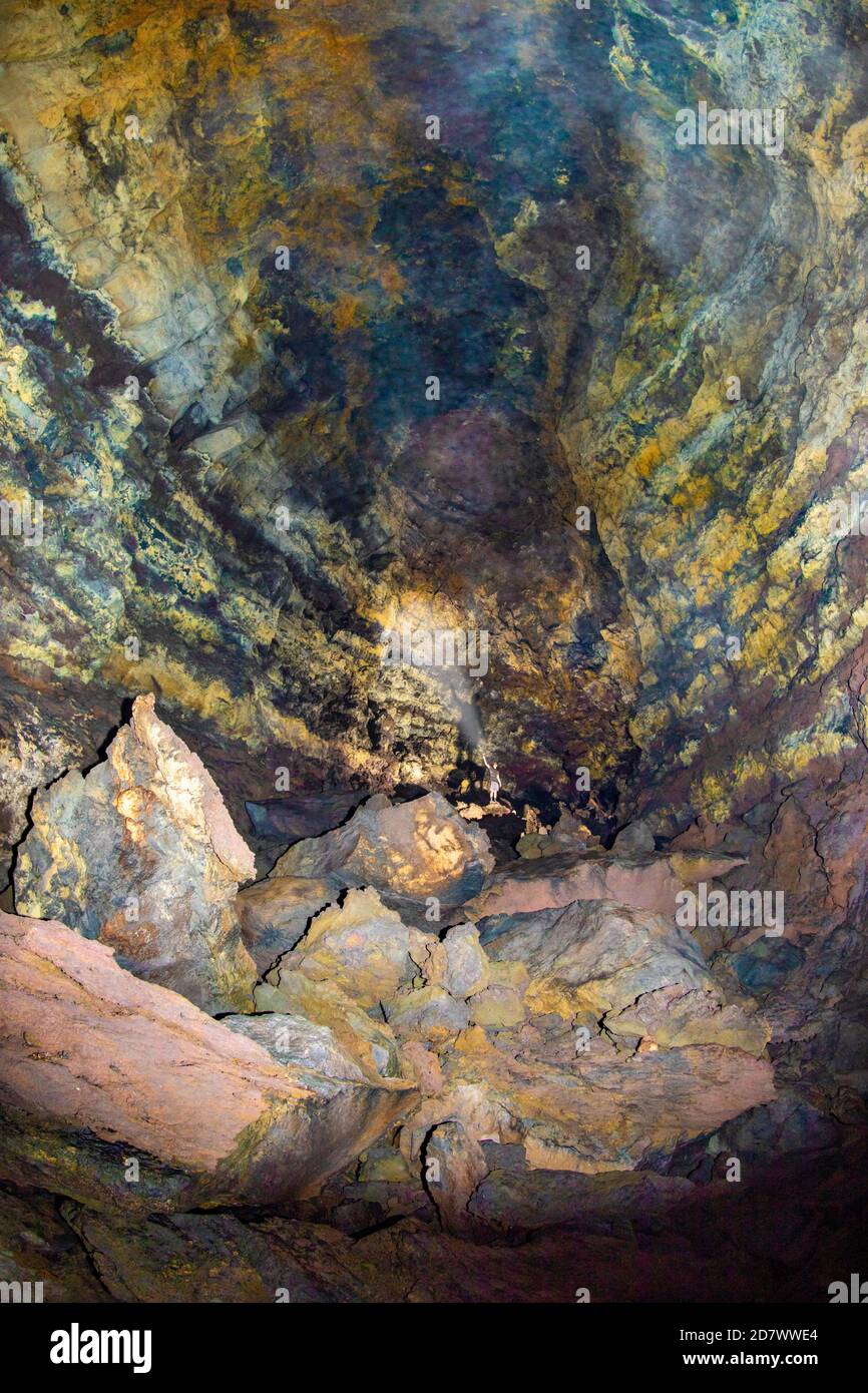 Ein Mann (MR) in einer riesigen Höhle, die Teil eines langen Lavatubus auf der Insel Maui, Hawaii ist. Stockfoto