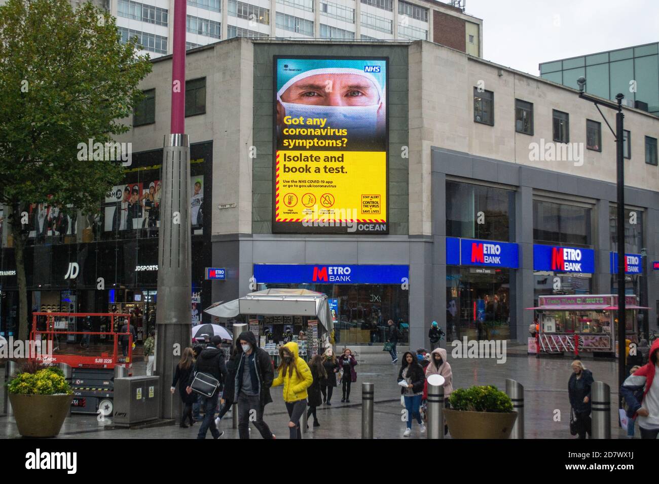 „Haben Sie irgendwelche Coronavirus-Symptome? Isolieren und buchen Sie ein Testschild in Birmingham, Großbritannien, wie die Stadt geht in Tier 2 High Alert Stockfoto