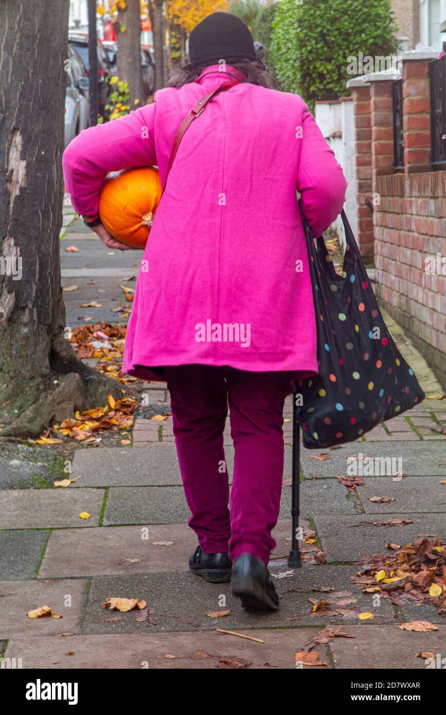 Eine Dame trägt einen Kürbis zu halloween nach Hause Stockfoto