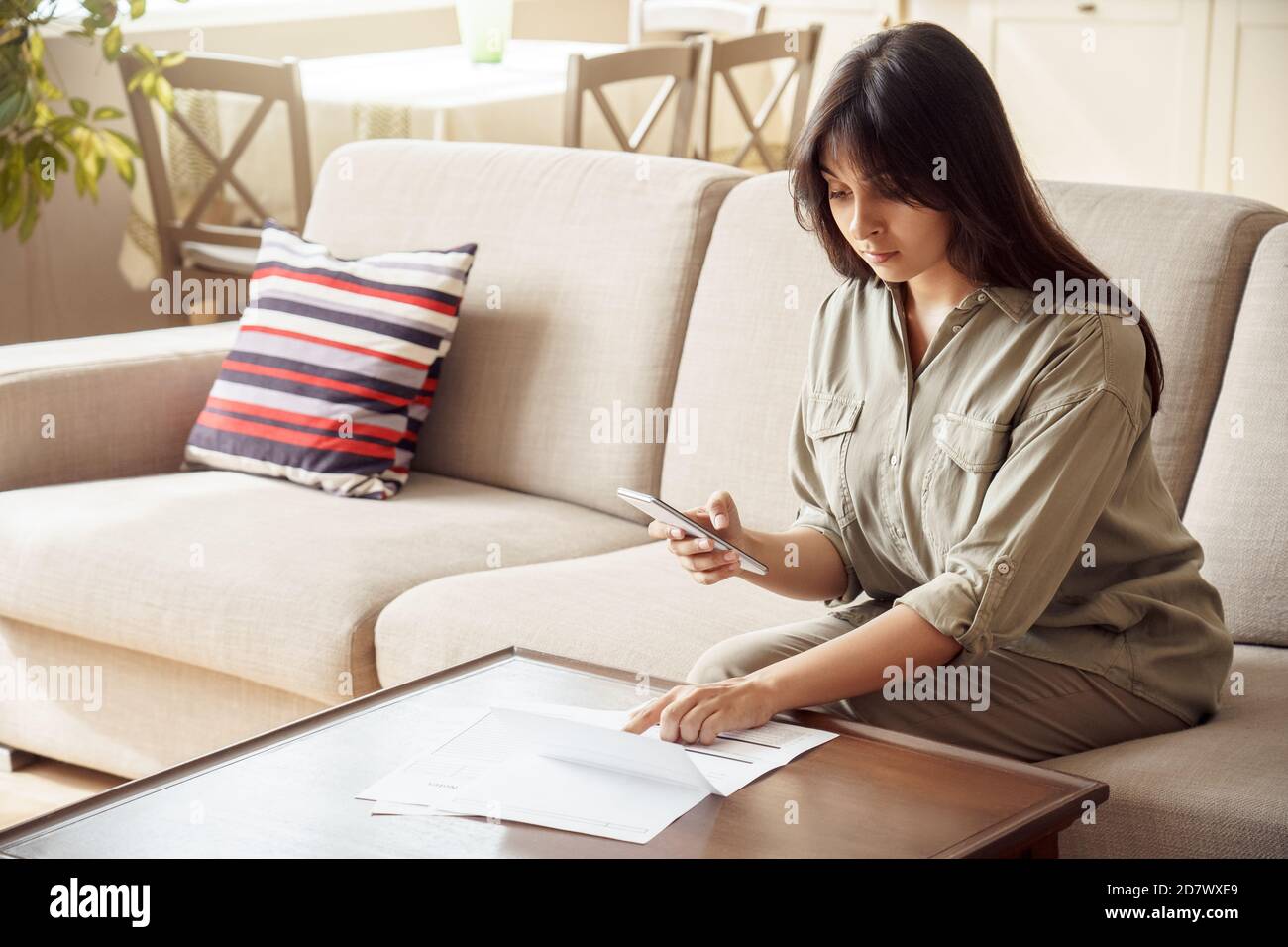 Indische Frau hält Telefon mit mobilen E-Bank-Anwendung Rechnungen bezahlen in App. Stockfoto