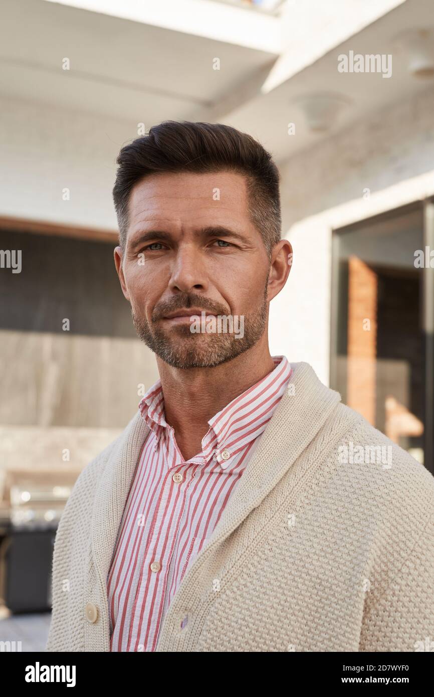 Vertikales Porträt von schönen reifen Mann Blick auf Kamera, während Auf der Außenterrasse stehen Stockfoto