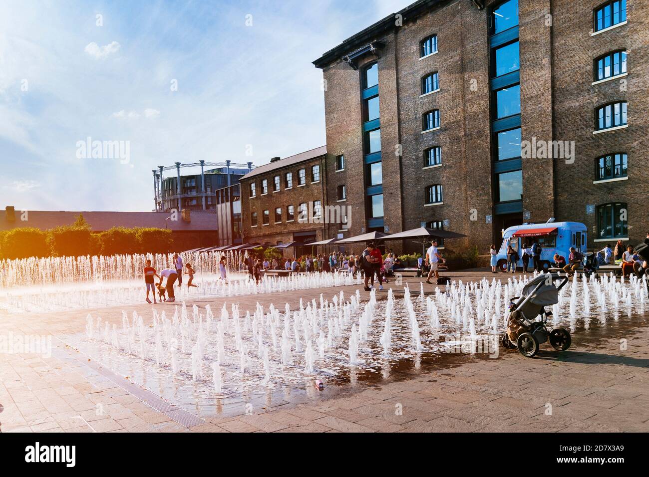 King's Cross London, Großbritannien, 12. Juli 2019: Kornspeicher-Platz Menschen genießen draußen, Brunnen Stockfoto